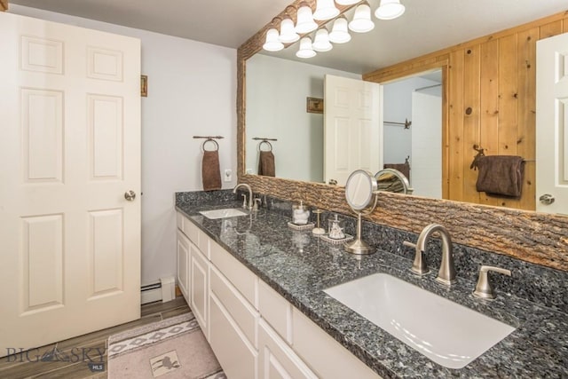 48042 Gallatin Rd, Big Sky, MT 59730 - full bathroom with double vanity, a baseboard radiator, and wood finished floors