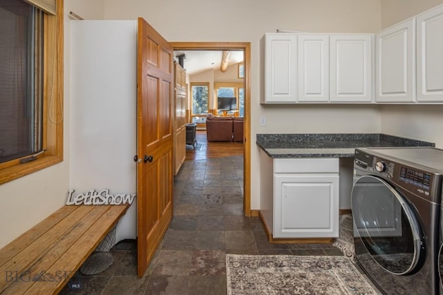 48042 Gallatin Rd, Big Sky, MT 59730 - laundry area featuring washer / clothes dryer, stone tile floors, cabinet space, and baseboards