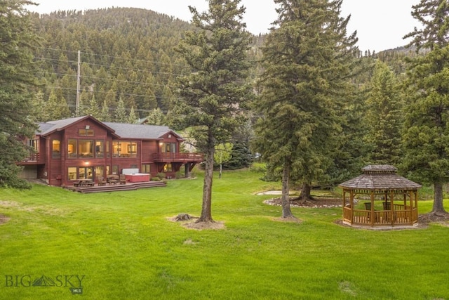 48042 Gallatin Rd, Big Sky, MT 59730 - view of green lawn featuring a gazebo, a view of trees, and a wooden deck