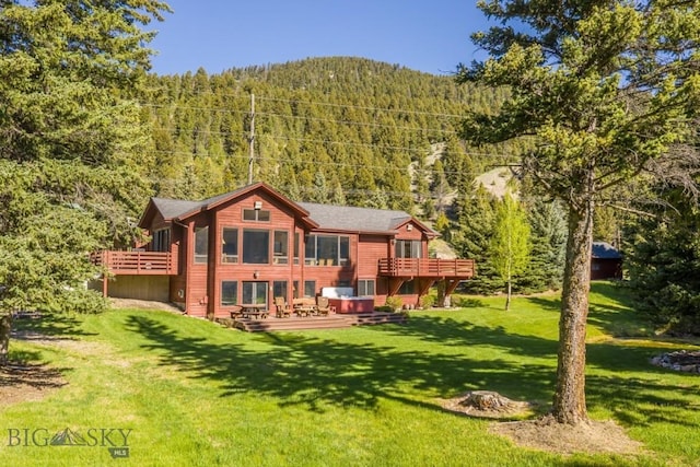 48042 Gallatin Rd, Big Sky, MT 59730 - back of house with a view of trees, a deck, and a yard