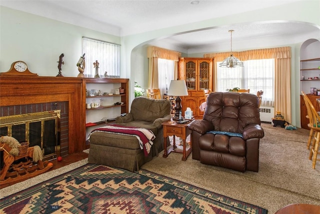510 S Excelsior, Butte, MT 59701 - carpeted living area featuring radiator heating unit, arched walkways, healthy amount of natural light, and a fireplace