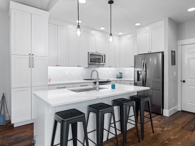 3171 Spring Ridge Dr, Bozeman, MT 59715 - kitchen with stainless steel appliances, dark wood-style floors, white cabinets, decorative backsplash, and recessed lighting