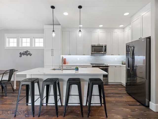 3171 Spring Ridge Dr, Bozeman, MT 59715 - kitchen with stainless steel appliances, white cabinetry, a breakfast bar, tasteful backsplash, and recessed lighting