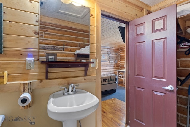 701 Bauer Ln Unit 2, Ennis, MT 59729 - bathroom with rustic walls, a sink, and wood finished floors