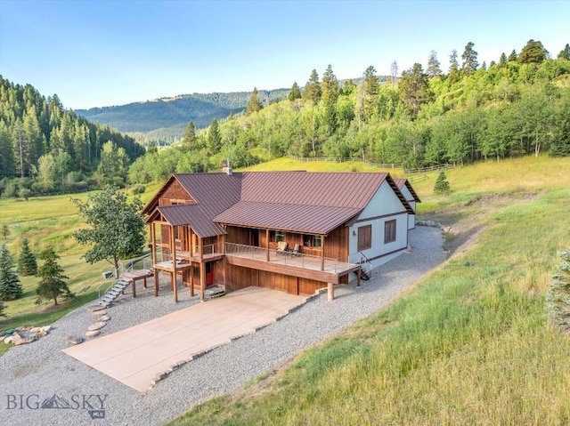 3011 Goose Creek Rd, Bozeman, MT 59715 - view of front facade featuring a porch, stairway, a forest view, metal roof, and gravel driveway