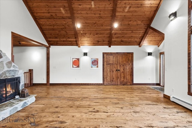3011 Goose Creek Rd, Bozeman, MT 59715 - unfurnished living room with wooden ceiling with exposed beams, wood finished floors, a baseboard radiator, a stone fireplace, and high vaulted ceiling