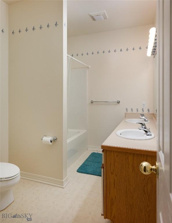 505 E Granite, Bozeman, MT 59718 - bathroom featuring toilet, baseboards,  shower combination, and double vanity
