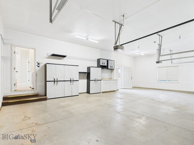 3405 W Fieldstone Dr, Bozeman, MT 59715 - garage featuring freestanding refrigerator, a garage door opener, and baseboards