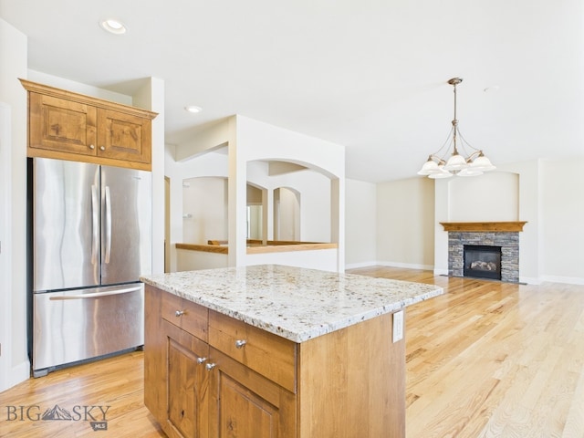 3405 W Fieldstone Dr, Bozeman, MT 59715 - kitchen with freestanding refrigerator, light wood finished floors, light stone counters, a kitchen island, and recessed lighting
