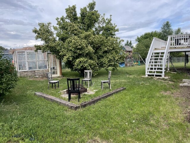 616 Comet, Livingston, MT 59047 - view of green lawn with a playground, a deck, and stairway