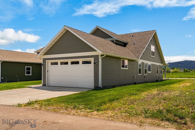 915 Arnold, Bozeman, MT 59715 - view of home's exterior with concrete driveway, a garage, roof with shingles, a lawn, and a mountain view