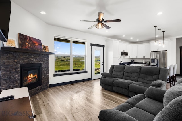 30 Blue Stem Way, Three Forks, MT 59752 - living room with a ceiling fan, a stone fireplace, recessed lighting, light wood finished floors, and baseboards