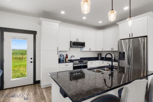 30 Blue Stem Way, Three Forks, MT 59752 - kitchen with appliances with stainless steel finishes, a sink, a kitchen breakfast bar, light wood finished floors, and white cabinetry