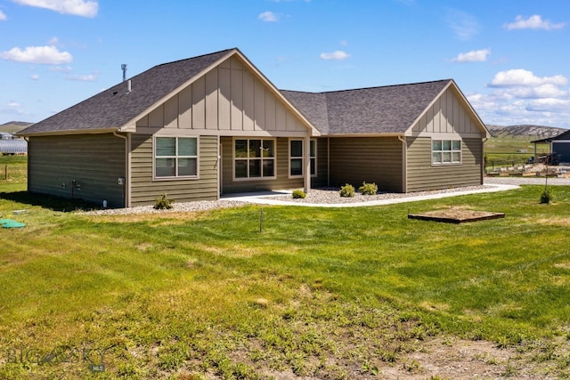 30 Blue Stem Way, Three Forks, MT 59752 - back of house with board and batten siding, a shingled roof, and a lawn