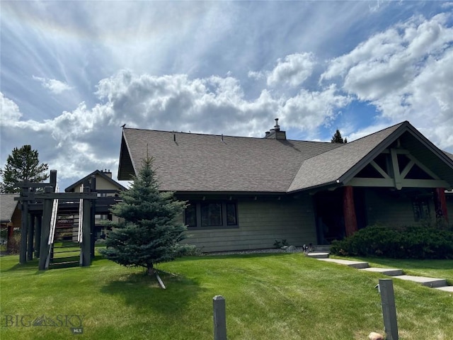 2225 Black Otter Rd Unit 23, Big Sky, MT 59716 - view of front of house with a front lawn, roof with shingles, and a chimney