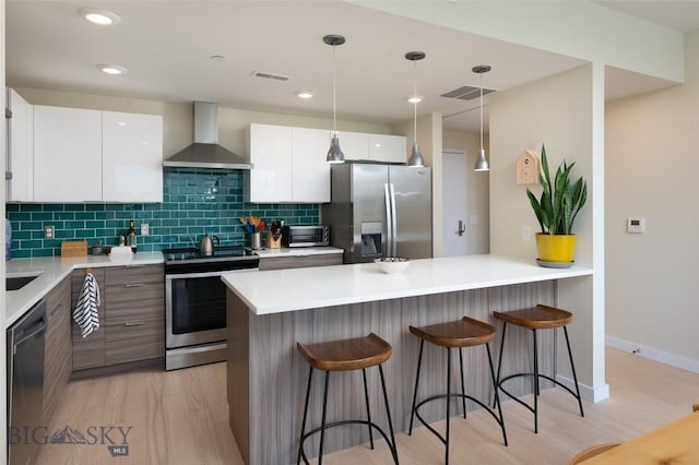 476 Enterprise Blvd Unit 207, Bozeman, MT 59718 - kitchen with appliances with stainless steel finishes, wall chimney exhaust hood, modern cabinets, a kitchen bar, and recessed lighting