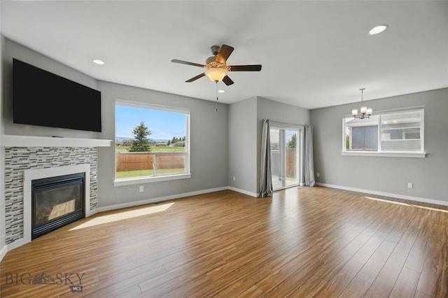 110 Ramshorn Peak Ln, Bozeman, MT 59718 - unfurnished living room featuring a ceiling fan, a tile fireplace, healthy amount of natural light, a chandelier, and recessed lighting