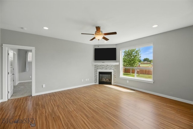 110 Ramshorn Peak Ln, Bozeman, MT 59718 - unfurnished living room with ceiling fan, a tile fireplace, baseboards, wood finished floors, and recessed lighting