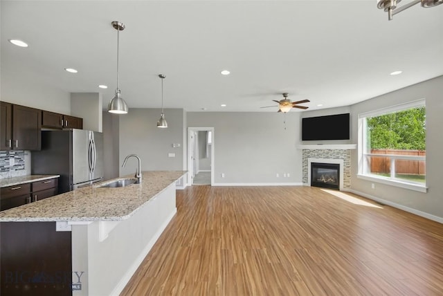 110 Ramshorn Peak Ln, Bozeman, MT 59718 - kitchen with freestanding refrigerator, a sink, dark brown cabinets, a ceiling fan, and light wood-style flooring