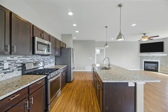 110 Ramshorn Peak Ln, Bozeman, MT 59718 - kitchen featuring stainless steel appliances, a sink, light wood-type flooring, backsplash, and a ceiling fan