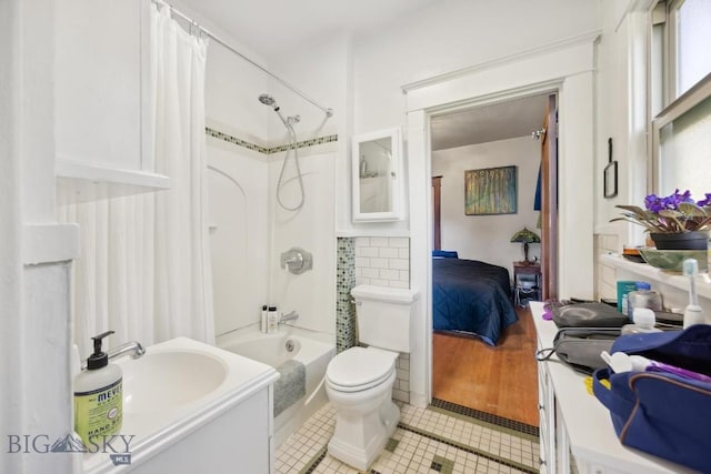521 S Washington, Butte, MT 59701 - bathroom featuring tile patterned flooring, connected bathroom, shower / bath combo with shower curtain, toilet, and a sink
