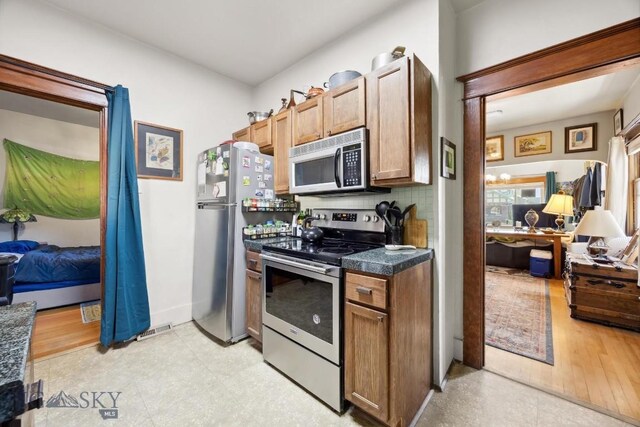 521 S Washington, Butte, MT 59701 - kitchen with stainless steel appliances, dark countertops, light flooring, and backsplash