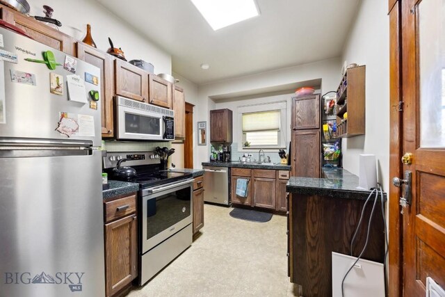 521 S Washington, Butte, MT 59701 - kitchen featuring appliances with stainless steel finishes, dark countertops, light flooring, and a sink