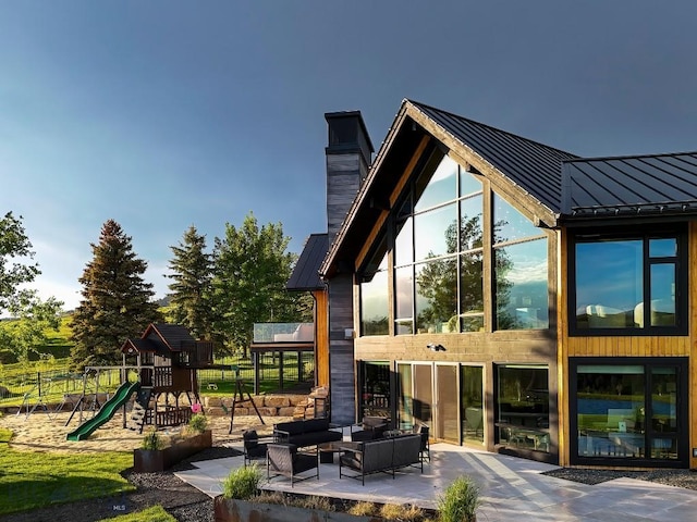 354 Brass Lantern Ct, Bozeman, MT 59715 - back of house with a standing seam roof, a chimney, an outdoor hangout area, a playground, and metal roof
