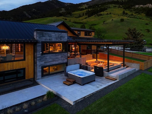 354 Brass Lantern Ct, Bozeman, MT 59715 - rear view of property with a standing seam roof, a fire pit, a patio, metal roof, and a mountain view