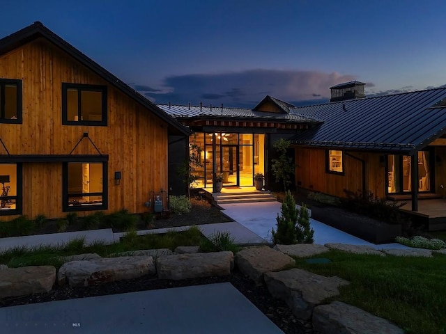 354 Brass Lantern Ct, Bozeman, MT 59715 - back of property featuring metal roof, a standing seam roof, a chimney, and central AC unit