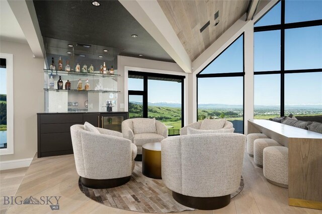 354 Brass Lantern Ct, Bozeman, MT 59715 - living area with light wood-type flooring, baseboards, lofted ceiling, and a bar