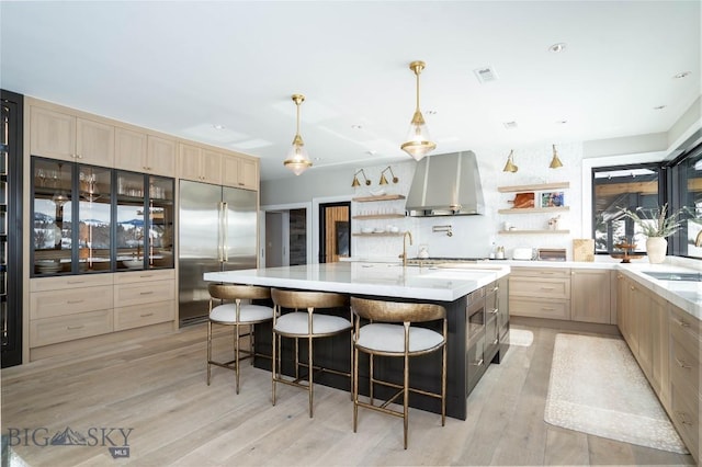 354 Brass Lantern Ct, Bozeman, MT 59715 - kitchen featuring built in refrigerator, open shelves, wall chimney exhaust hood, light brown cabinetry, and light countertops