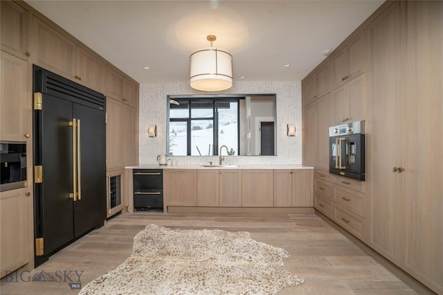 354 Brass Lantern Ct, Bozeman, MT 59715 - kitchen with paneled refrigerator, oven, light wood-style flooring, light countertops, and a sink