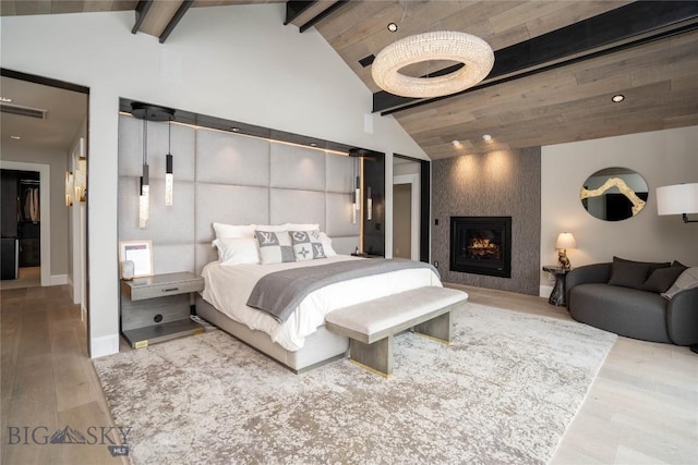 354 Brass Lantern Ct, Bozeman, MT 59715 - bedroom with beamed ceiling, wood finished floors, a fireplace, recessed lighting, and high vaulted ceiling