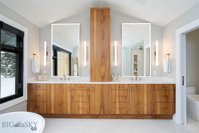 354 Brass Lantern Ct, Bozeman, MT 59715 - bathroom featuring toilet, double vanity, vaulted ceiling, and a soaking tub