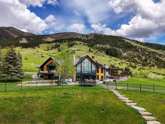 354 Brass Lantern Ct, Bozeman, MT 59715 - rear view of house featuring a playground, a mountain view, a chimney, and a patio