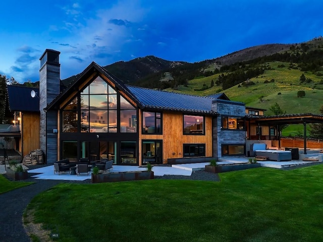 354 Brass Lantern Ct, Bozeman, MT 59715 - back of house with outdoor lounge area, a patio area, a yard, a mountain view, and a chimney
