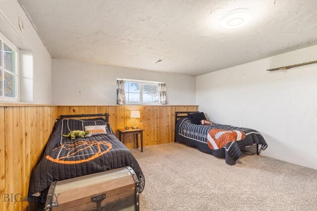 251 Price Rd, Three Forks, MT 59752 - bedroom featuring wooden walls, carpet floors, and a wainscoted wall