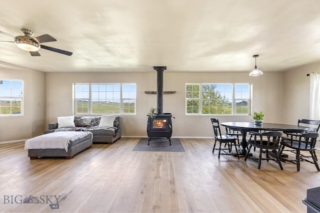 251 Price Rd, Three Forks, MT 59752 - living room with a wood stove, light wood-type flooring, baseboards, and ceiling fan