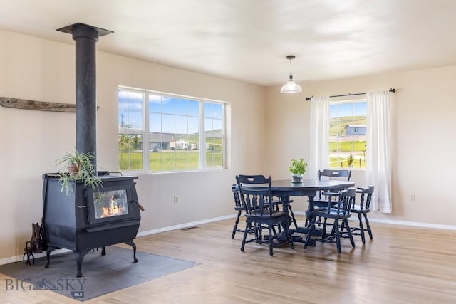 251 Price Rd, Three Forks, MT 59752 - dining room featuring a wood stove, wood finished floors, and baseboards