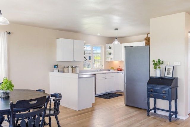 251 Price Rd, Three Forks, MT 59752 - kitchen featuring freestanding refrigerator, light wood-style flooring, white cabinets, pendant lighting, and a sink