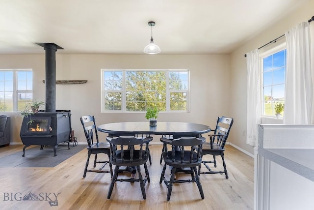 251 Price Rd, Three Forks, MT 59752 - dining space featuring a wood stove, healthy amount of natural light, and light wood-style flooring