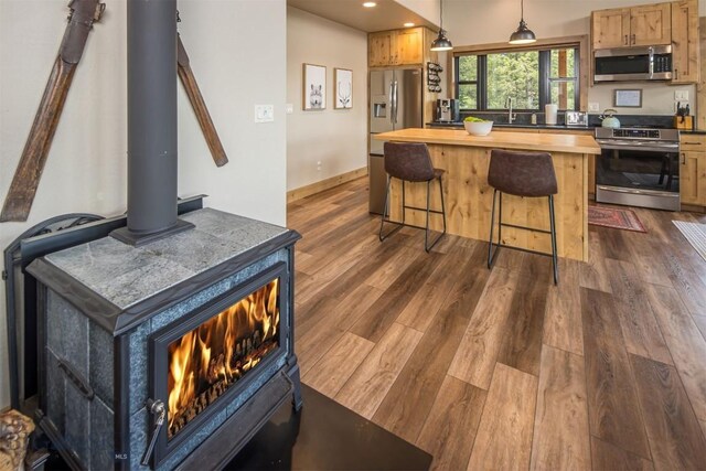 TBD Buttermilk Court, West Yellowstone, MT 59758 - kitchen featuring appliances with stainless steel finishes, a kitchen bar, dark wood-style floors, recessed lighting, and a center island