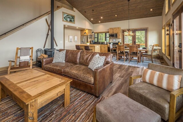 TBD Buttermilk Court, West Yellowstone, MT 59758 - living room featuring dark wood finished floors, a chandelier, high vaulted ceiling, wood ceiling, and a wood stove