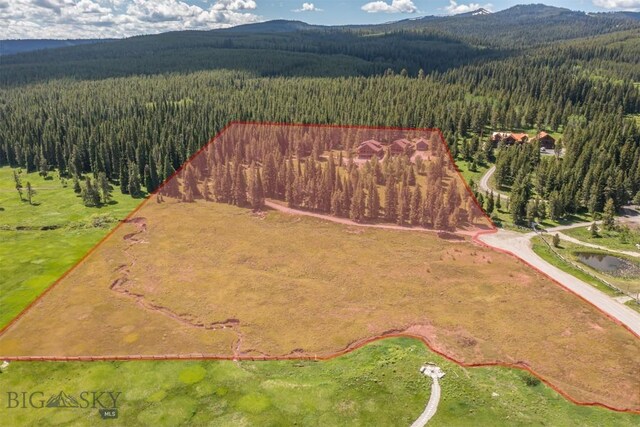 TBD Buttermilk Court, West Yellowstone, MT 59758 - aerial view of property's location featuring a forest, a mountainous background, and property boundaries highlighted