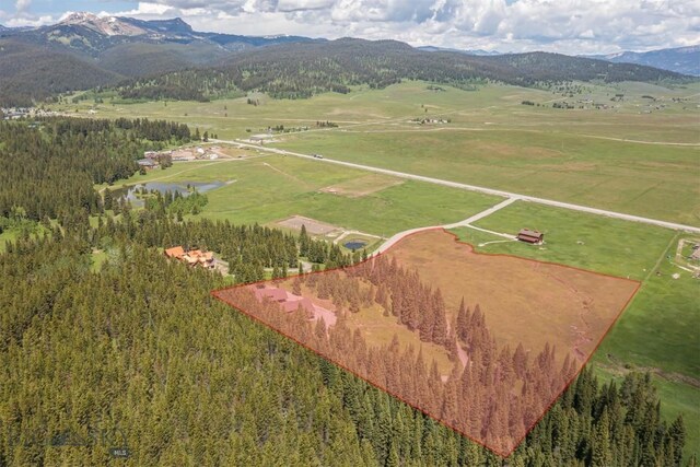 TBD Buttermilk Court, West Yellowstone, MT 59758 - aerial view of property and surrounding area with property parcel outlined, a heavily wooded area, and a water and mountain view