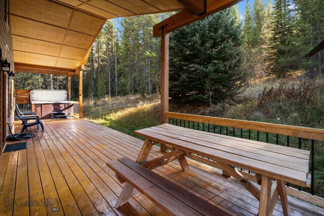 TBD Buttermilk Court, West Yellowstone, MT 59758 - wooden terrace featuring a hot tub, outdoor dining area, and a view of trees