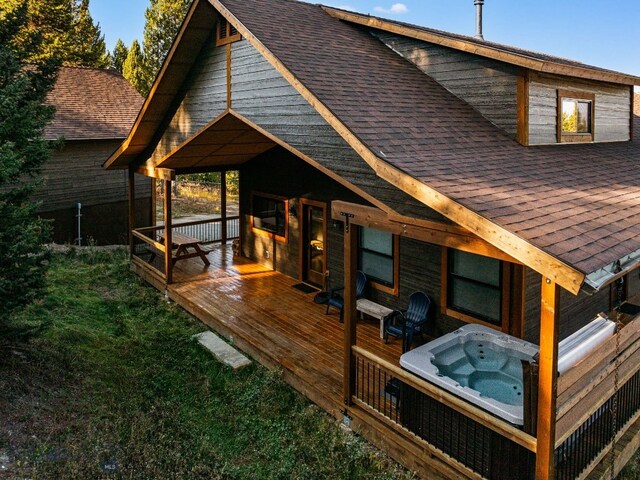 TBD Buttermilk Court, West Yellowstone, MT 59758 - back of house featuring a shingled roof, a hot tub, and a wooden deck