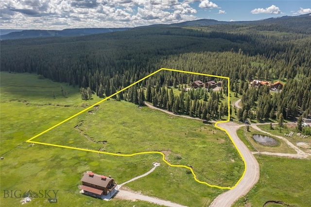 TBD Buttermilk Court, West Yellowstone, MT 59758 - aerial view of property and surrounding area with a heavily wooded area, mountains, and property boundaries highlighted