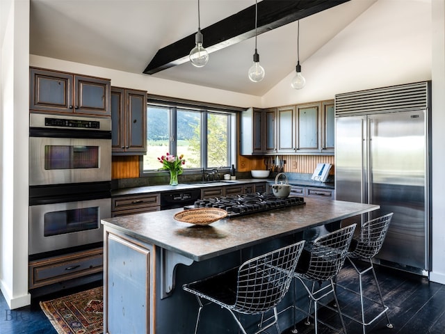 370 Star Ridge Rd, Bozeman, MT 59715 - kitchen with appliances with stainless steel finishes, dark countertops, a kitchen breakfast bar, and hanging light fixtures
